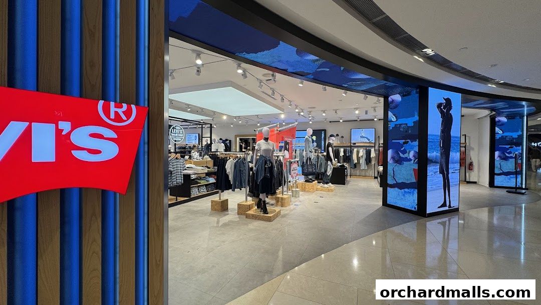 The entrance of a Levi's store with mannequins displaying clothing and large digital screens.