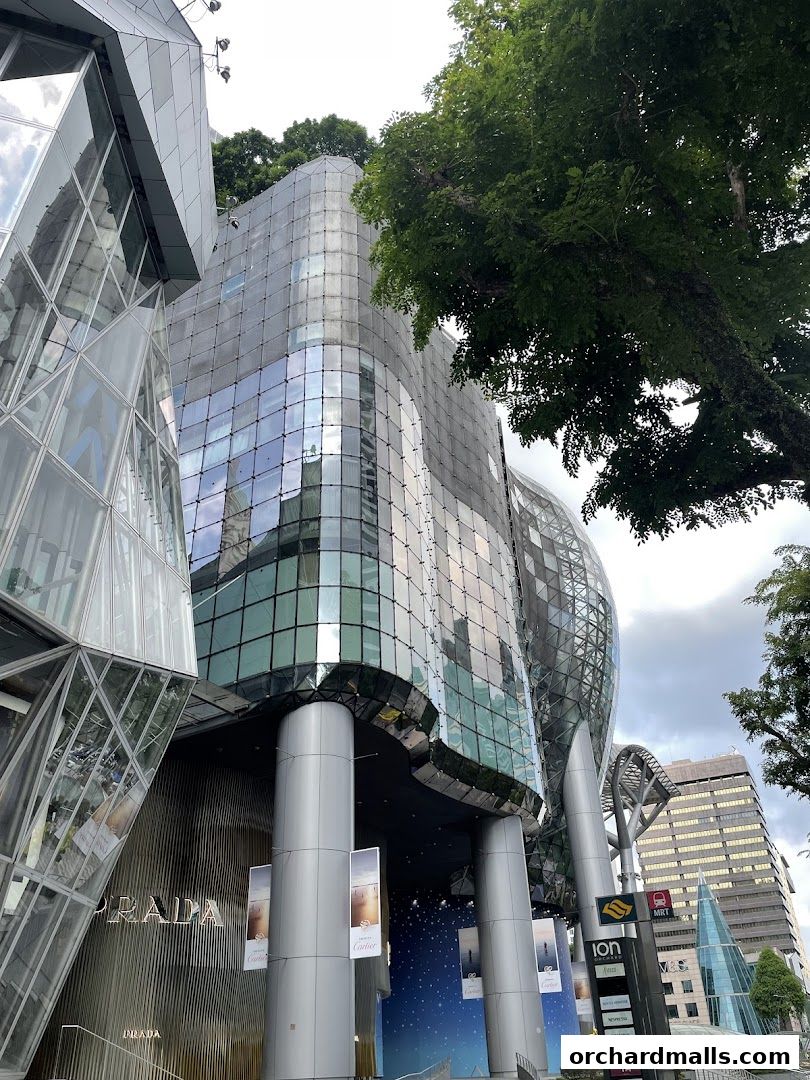 Exterior view of the ION Orchard building with Prada and other luxury brand storefronts.
