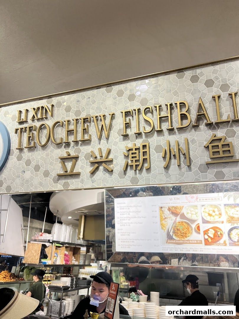 A view of the Li Xin Teochew Fishball Noodles shop counter with staff and menu visible.