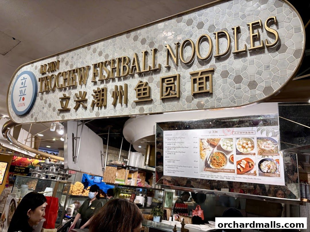A menu board for Li Xin Teochew Fishball Noodles with various noodle dishes and prices.