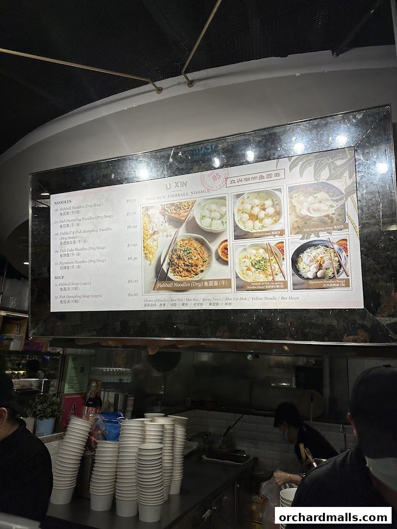 A menu board for Li Xin Teochew Fishball Noodles with various noodle and soup options.