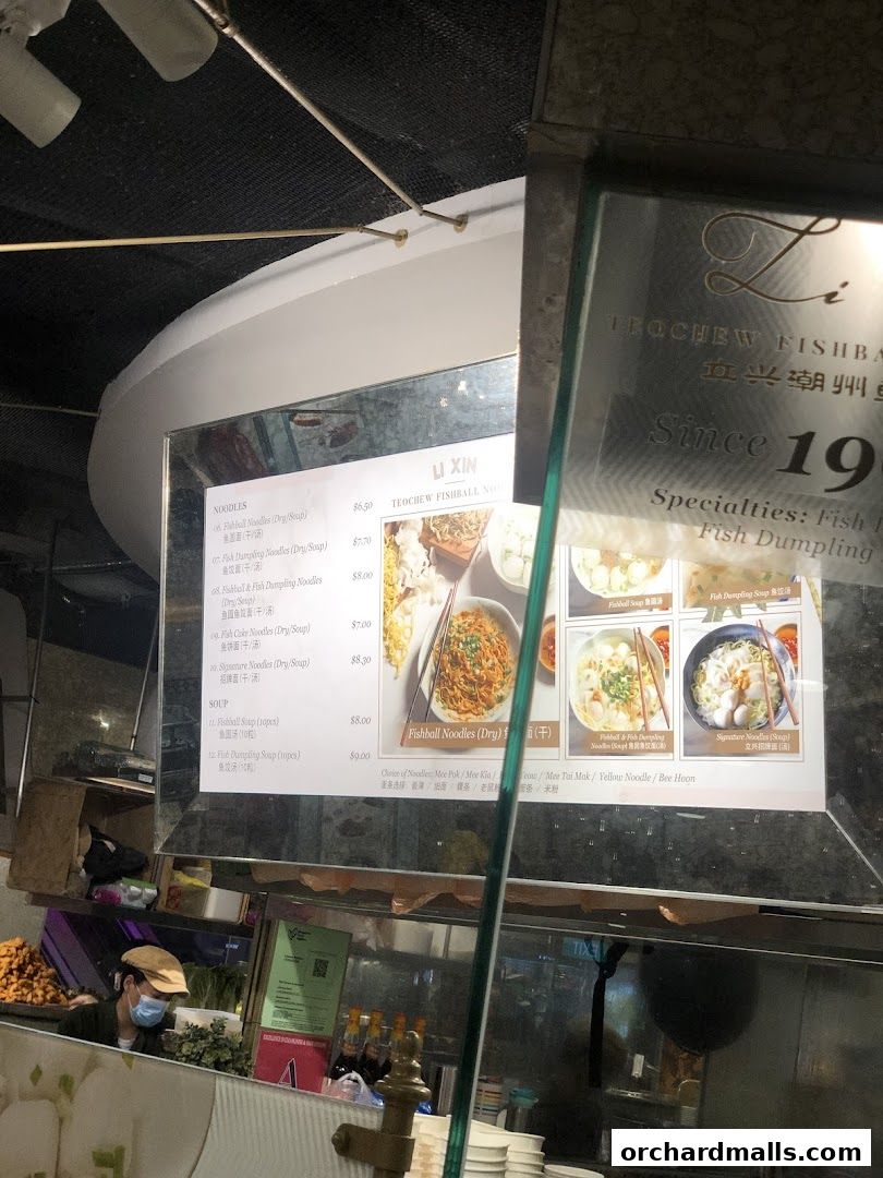 A menu board for Li Xin Teochew Fishball Noodles, showcasing various noodle and soup dishes with prices.