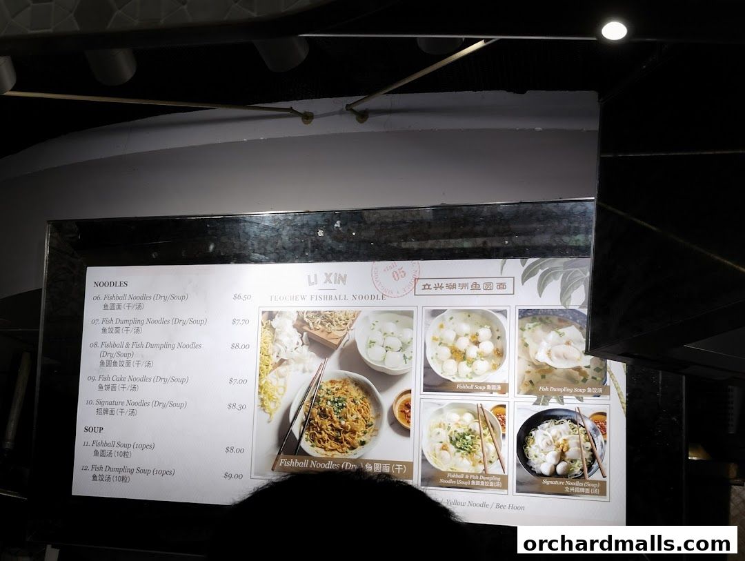 A menu board for Li Xin Teochew Fishball Noodles, showcasing various noodle and soup dishes with prices.
