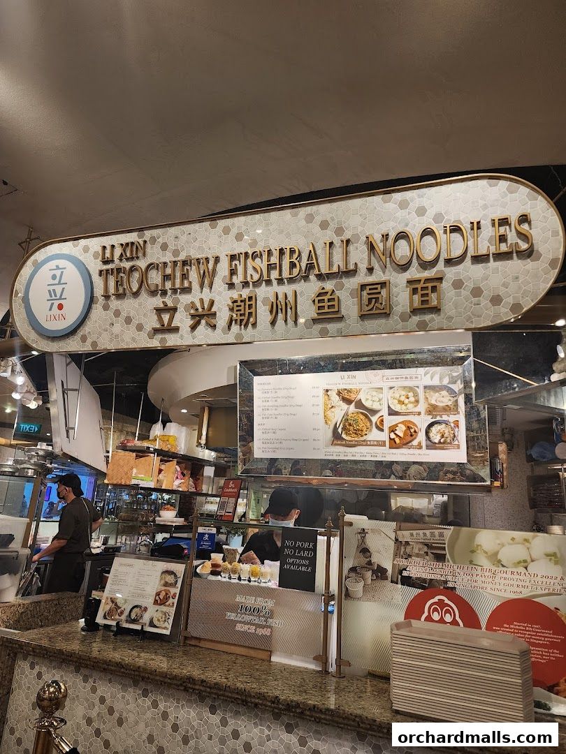 Li Xin Teochew Fishball Noodles shop front with menu and staff serving customers.