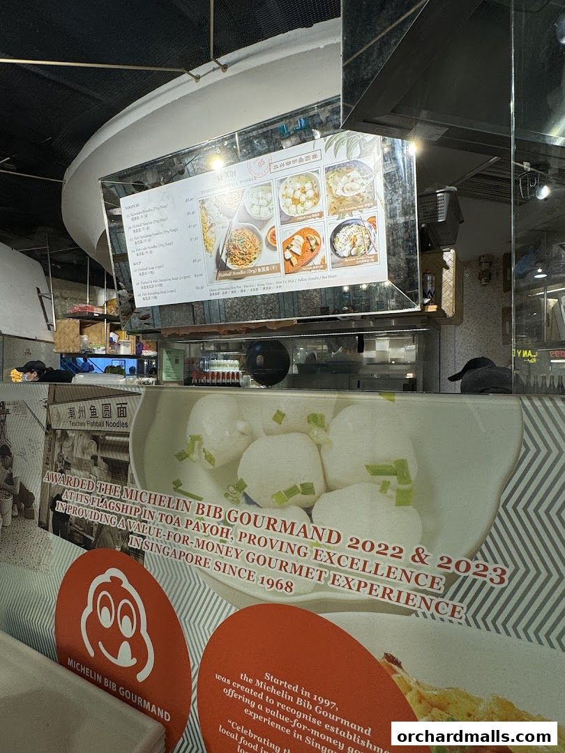 A menu board for LiXin Teochew Fishball Noodles, showcasing dishes and awards.