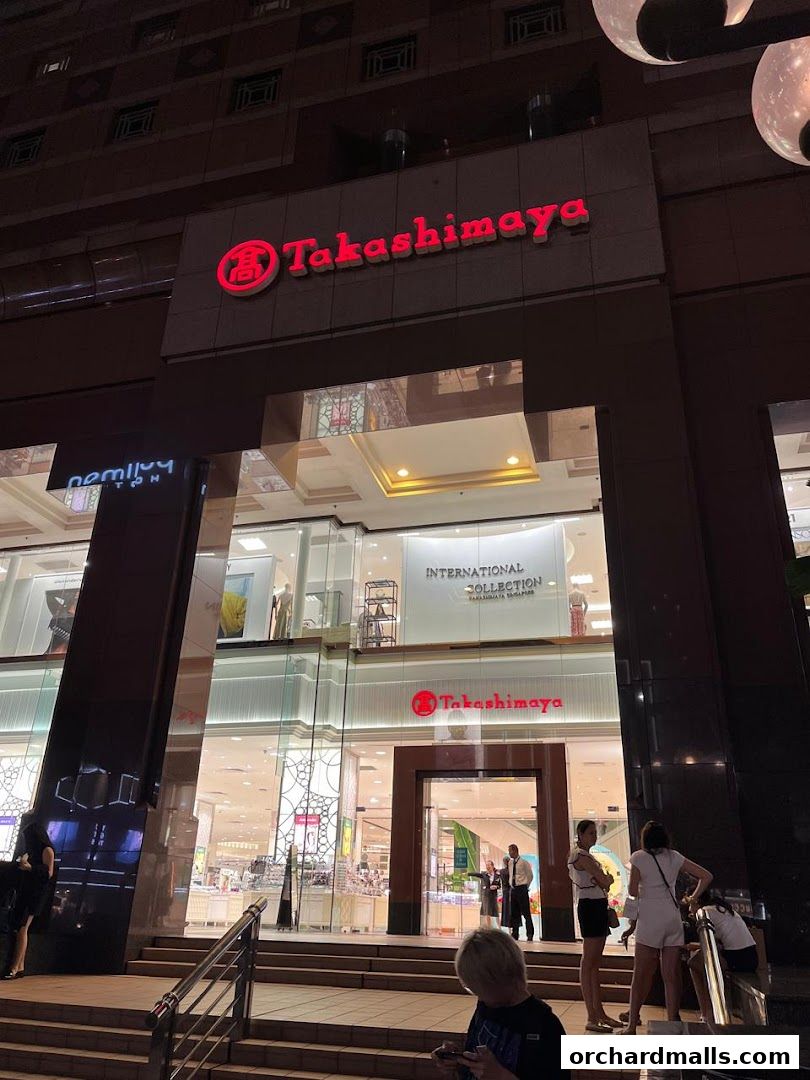 The illuminated entrance of Takashimaya department store at night.