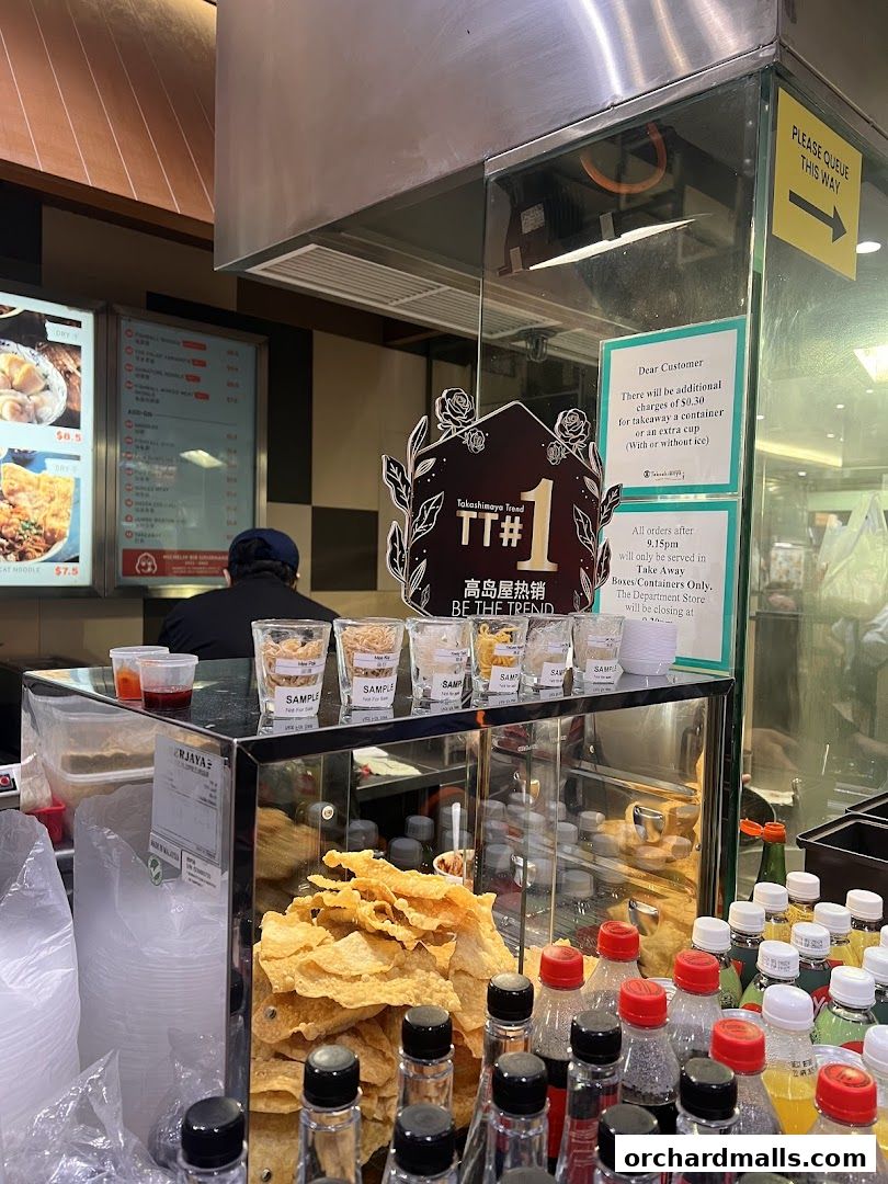 A display of food samples and bottled drinks at a food stall.