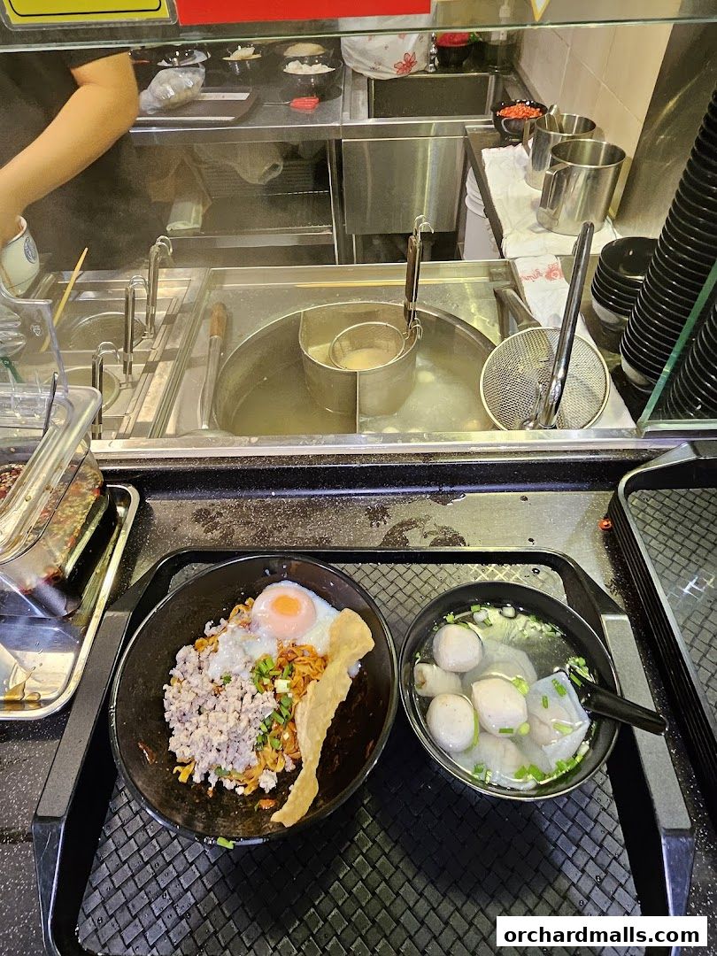 A delicious bowl of Teochew fishball noodles with minced meat and a fried egg.