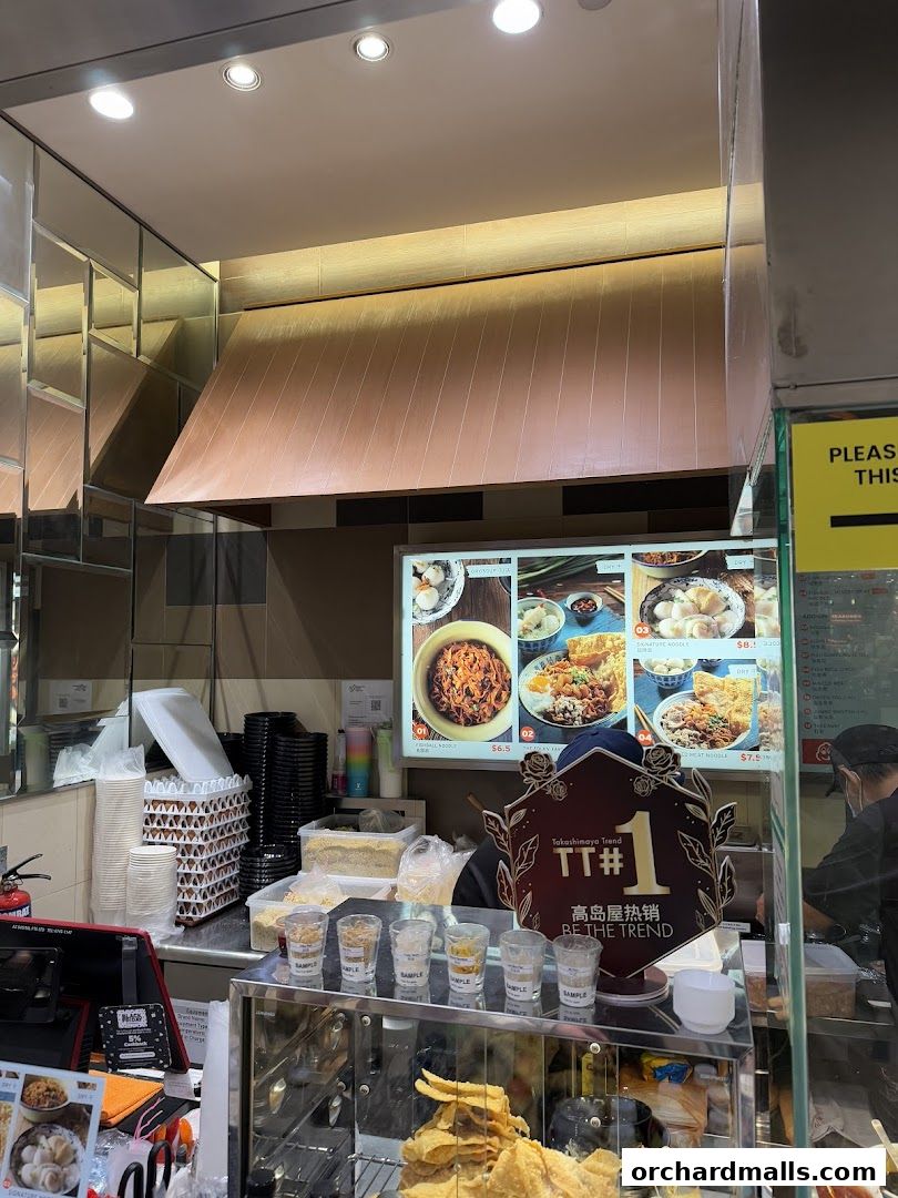 A food stall counter displaying menu items and samples of ingredients.
