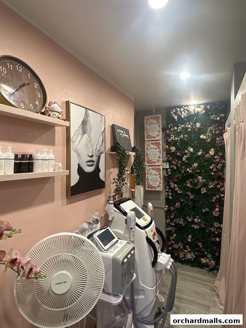 Interior of Liz Aesthetics with beauty equipment, decor, and a floral wall.
