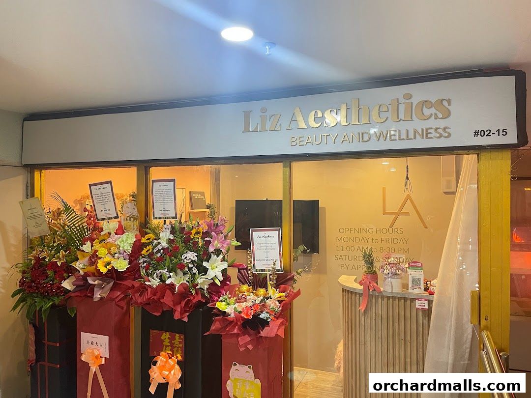 The entrance of Liz Aesthetics, a beauty and wellness shop, decorated with floral arrangements.