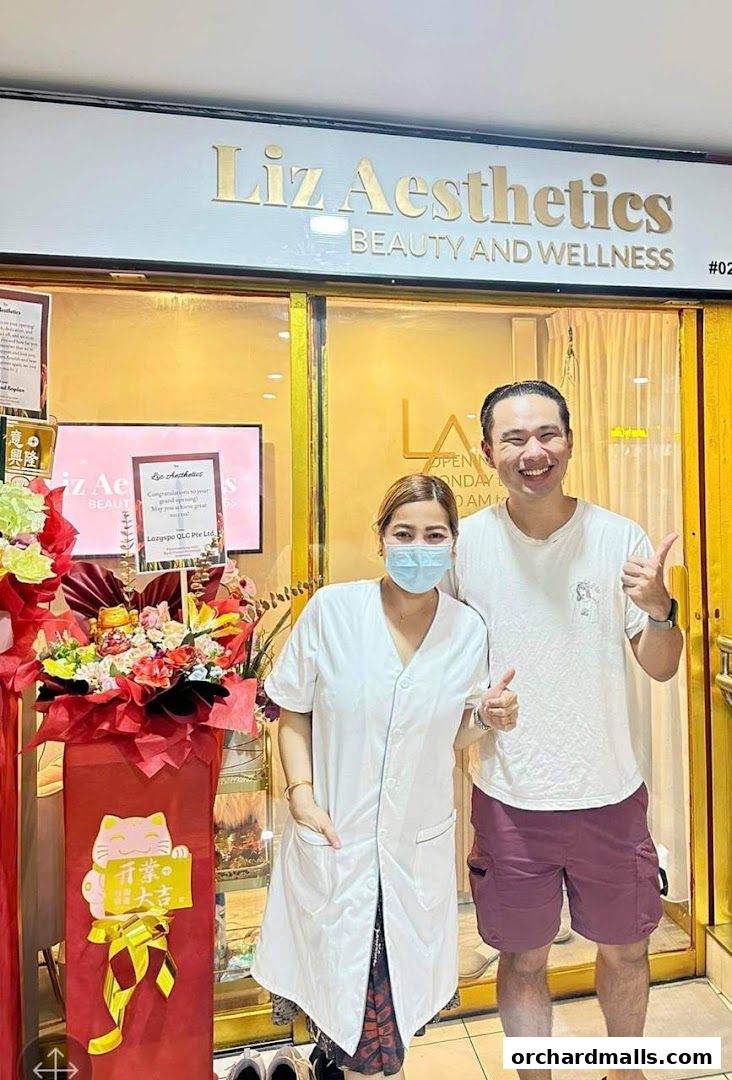 Two people smiling in front of Liz Aesthetics beauty and wellness shop.