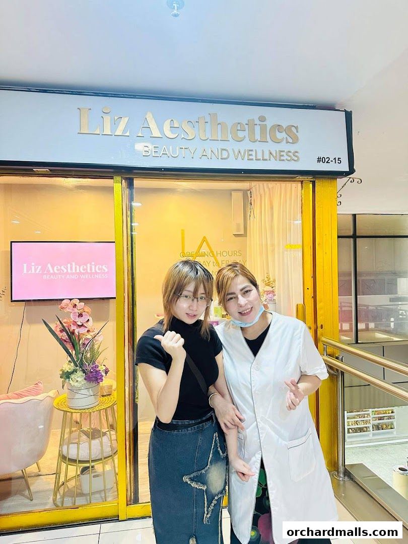 Two women stand in front of the Liz Aesthetics beauty and wellness shop.