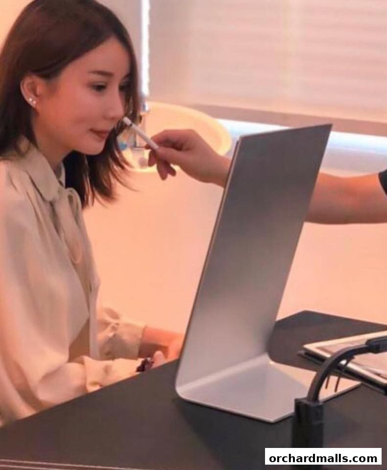 A woman is being assisted with a medical device near her nose by another person.