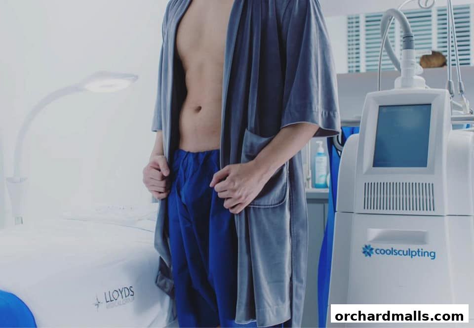 A person in a robe stands next to a CoolSculpting machine at Lloyds Medical Group.