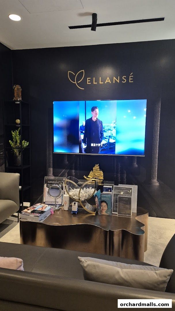 Interior of a modern medical spa with a large screen displaying a video and a display table.