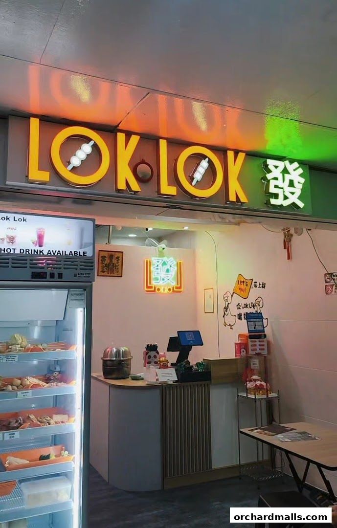 The exterior of a Lok Lok Fa restaurant with a prominent neon sign and a display fridge.