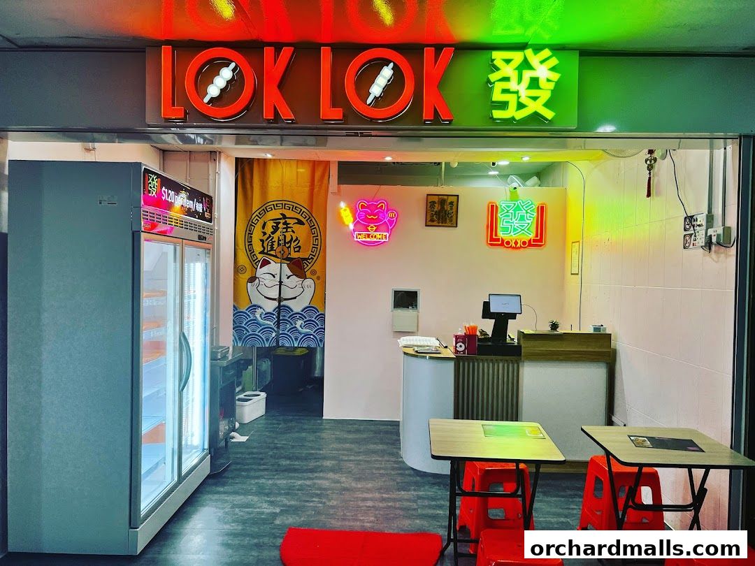 The entrance of Lok Lok Fa 發, a vibrant eatery with neon signs and a display fridge.