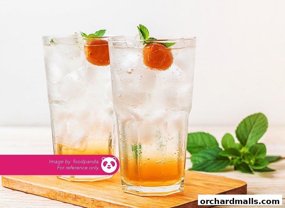 Two refreshing glasses of plum soda with ice, mint, and a plum garnish.