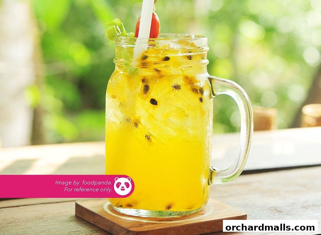 A refreshing passion fruit drink in a mason jar with ice and mint.