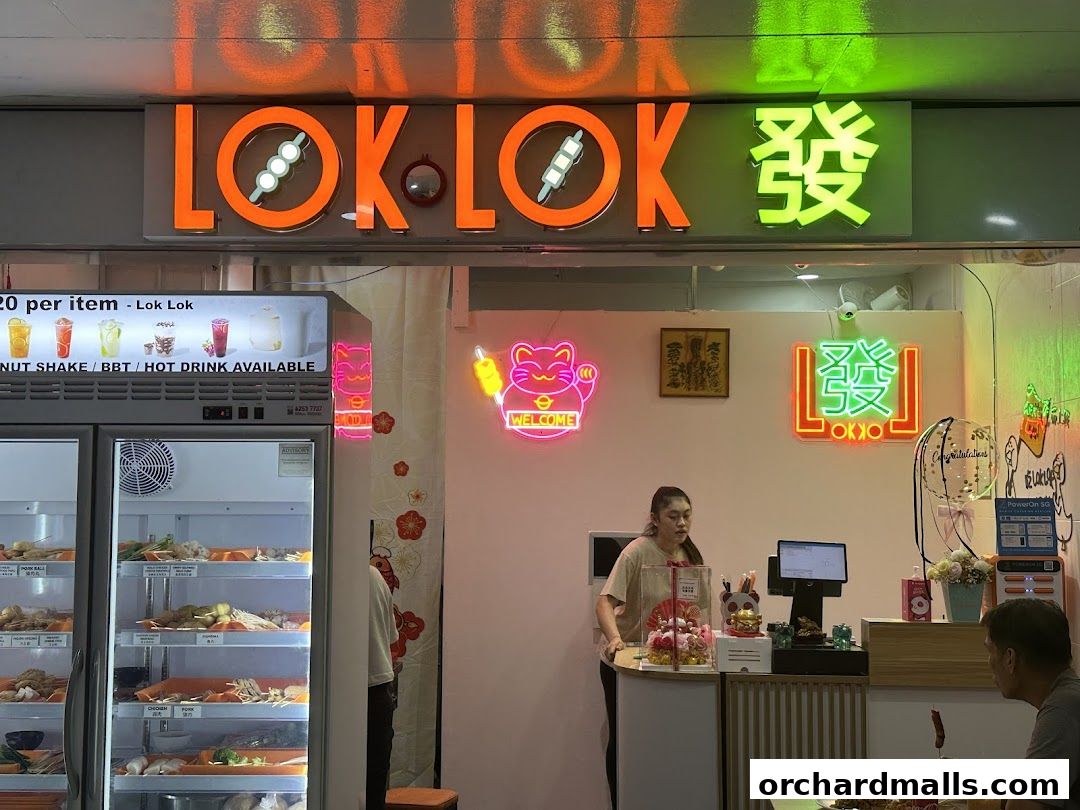 A brightly lit Lok Lok shop with a display fridge and a cashier counter.