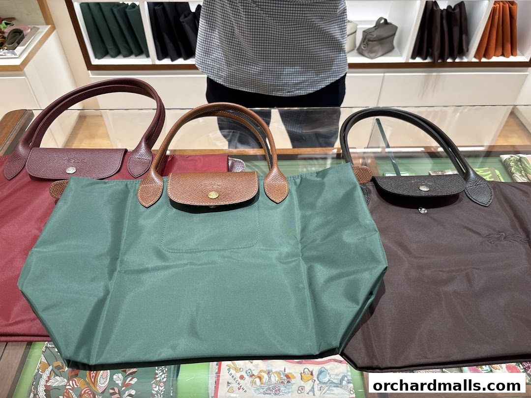 A display of colorful Longchamp tote bags in various sizes and colors.