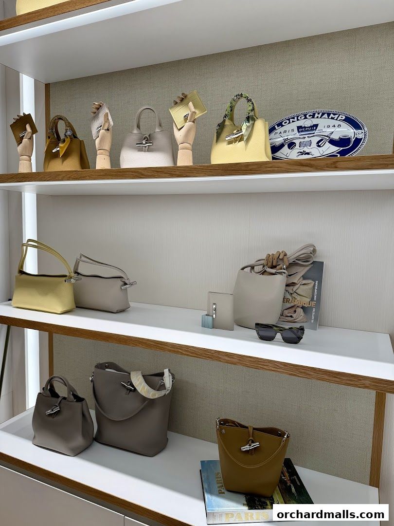 A display of Longchamp handbags and accessories on shelves, showcasing various styles and colors.