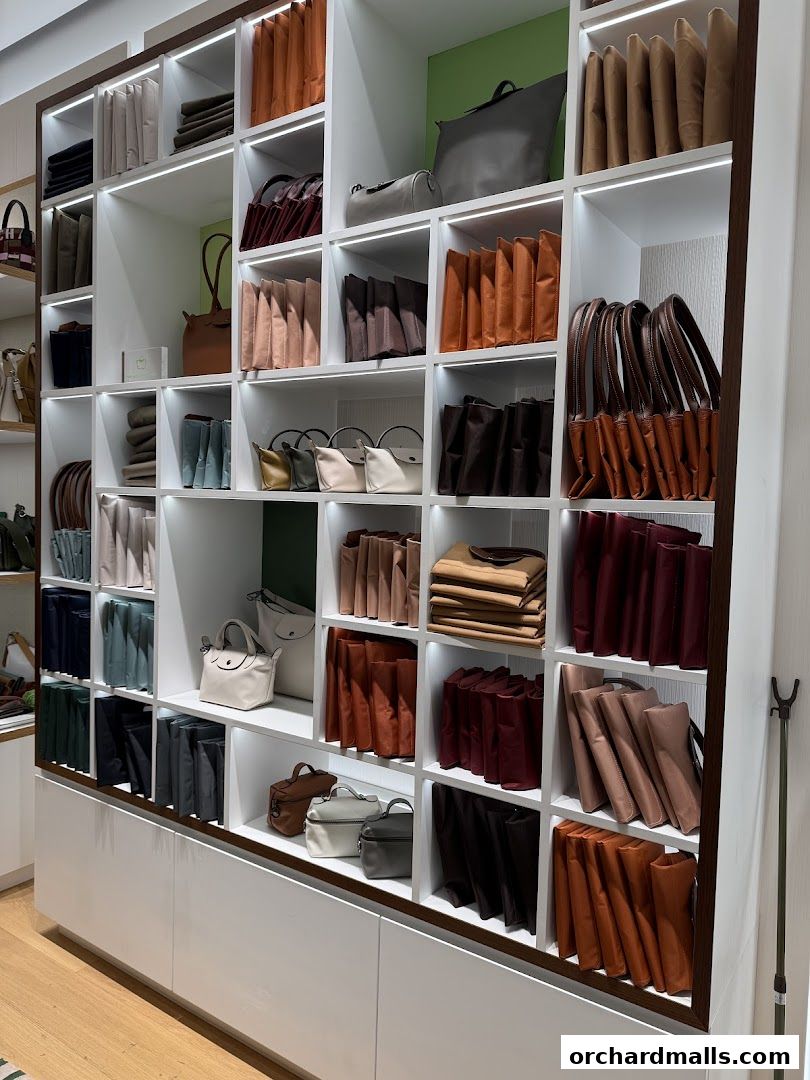 A well-lit display of Longchamp handbags in various colors and styles on shelves.