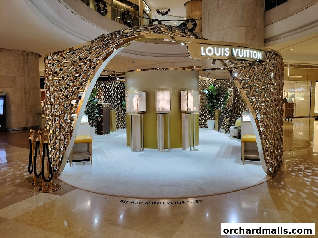 The Louis Vuitton store features a striking golden, geometric facade with illuminated display cases inside.