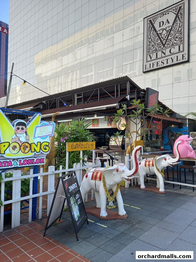 A street-level view of a restaurant with elephant statues and signage.