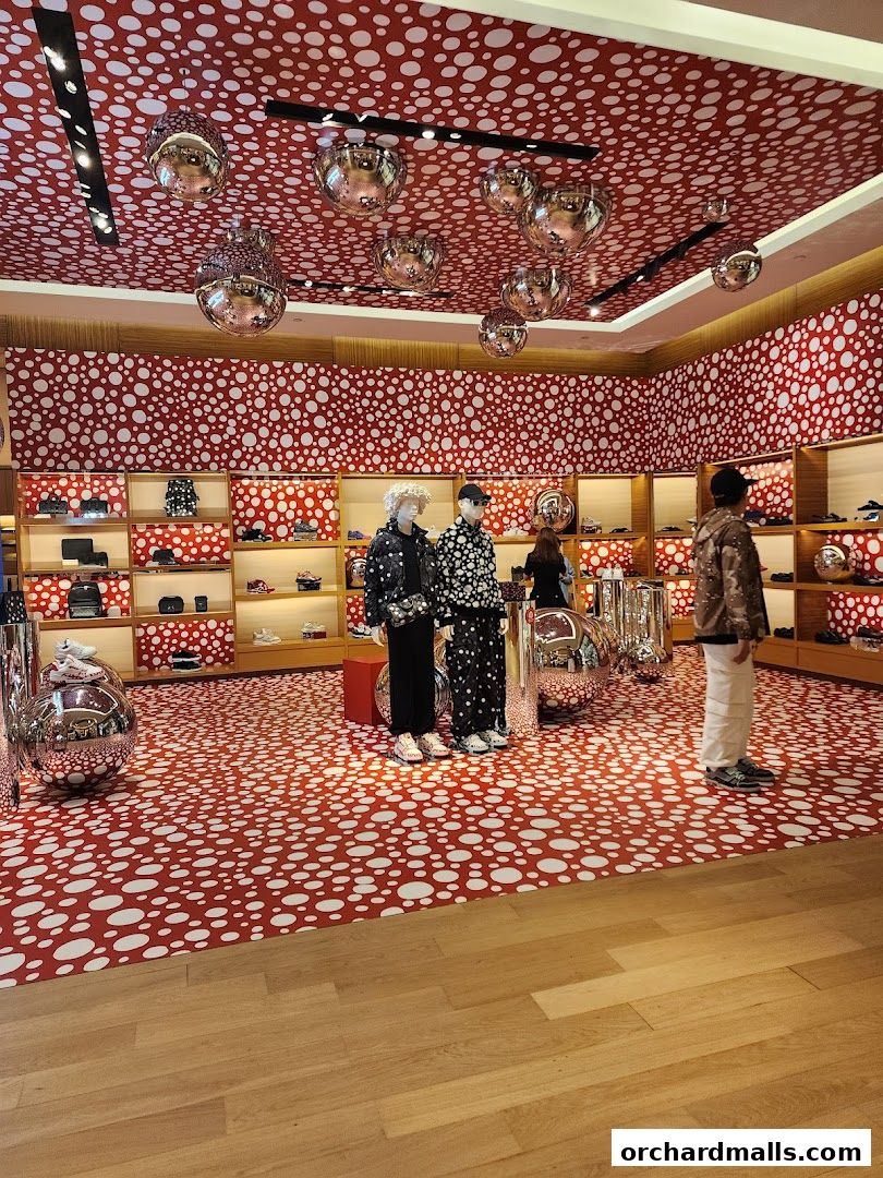 Interior of a Louis Vuitton store with polka dot decor and mannequins.