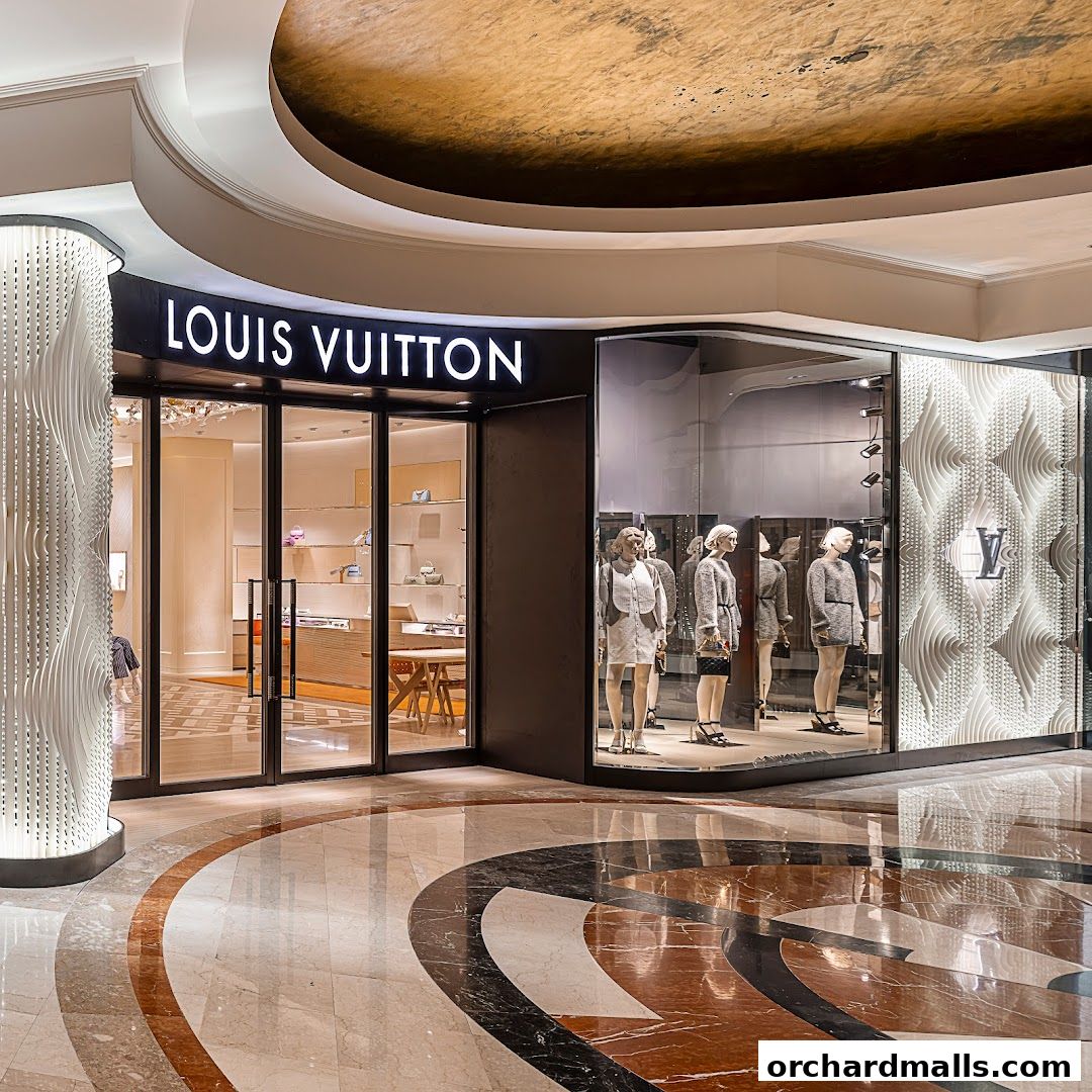 Exterior view of a Louis Vuitton store with mannequins in the window display.