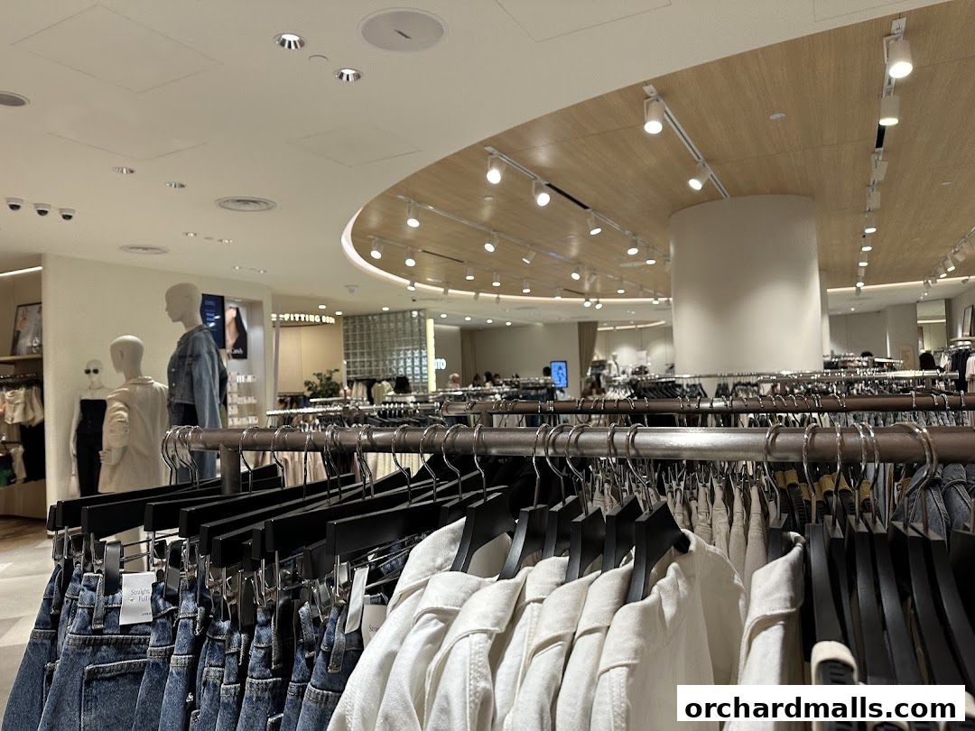Interior view of a clothing store with racks of apparel and mannequins.