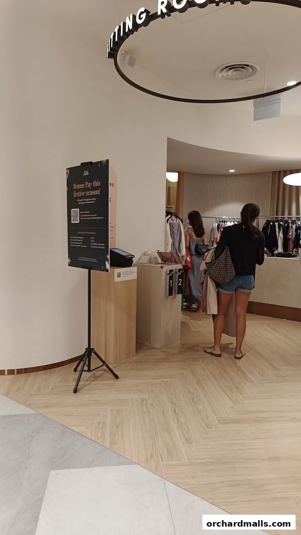 Customers browsing clothes inside a modern boutique with fitting rooms.