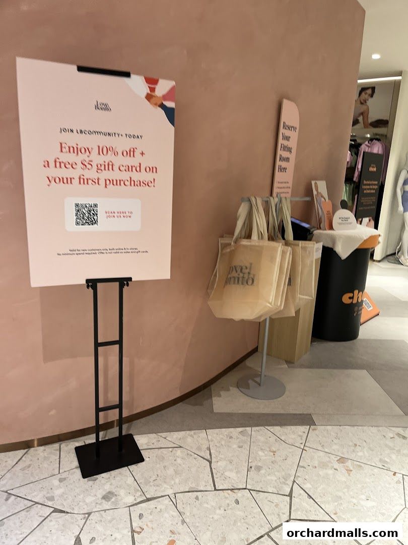 A sign offers a discount and gift card for joining the LBCommunity, with shopping bags nearby.