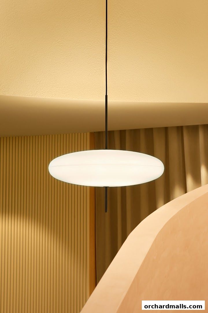 A modern interior with a large oval pendant light and textured walls.
