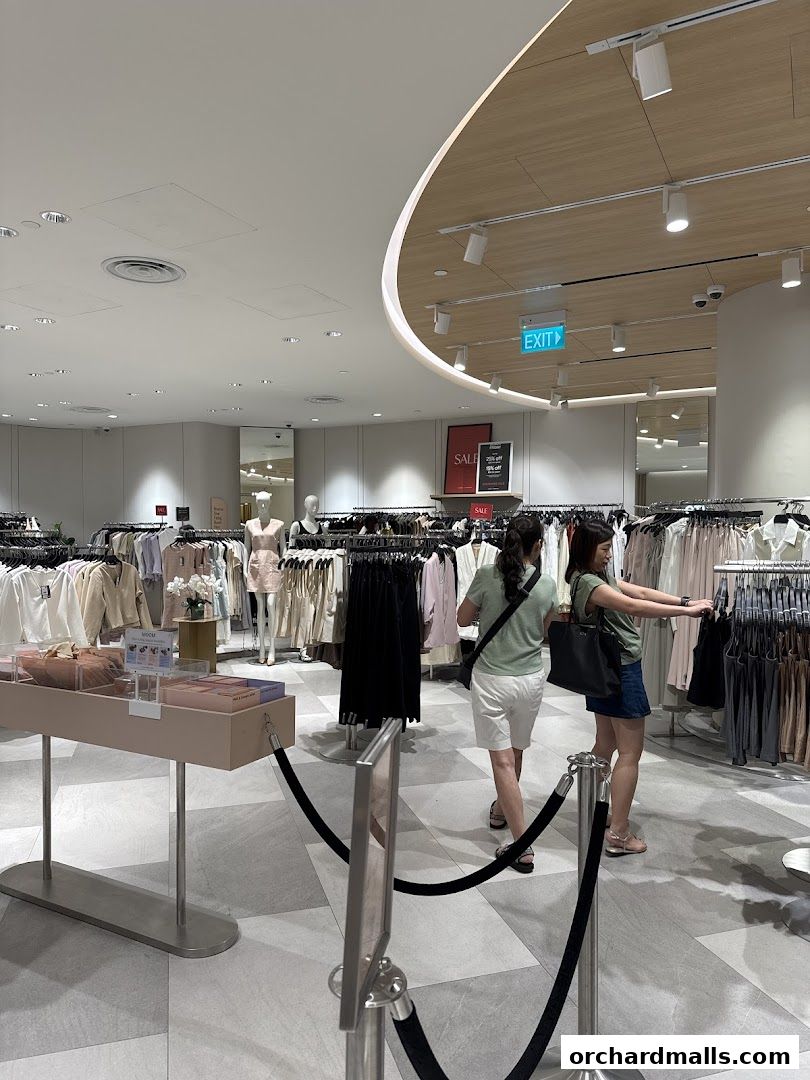 Customers browsing stylish women's clothing racks inside a modern boutique.