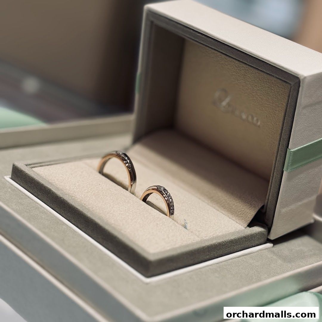 A close-up of two diamond-studded wedding bands in a luxurious ring box.
