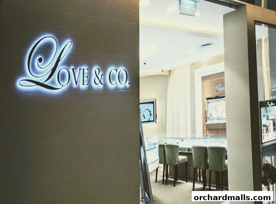 The illuminated Love & Co. logo is displayed on a wall next to the shop's interior.