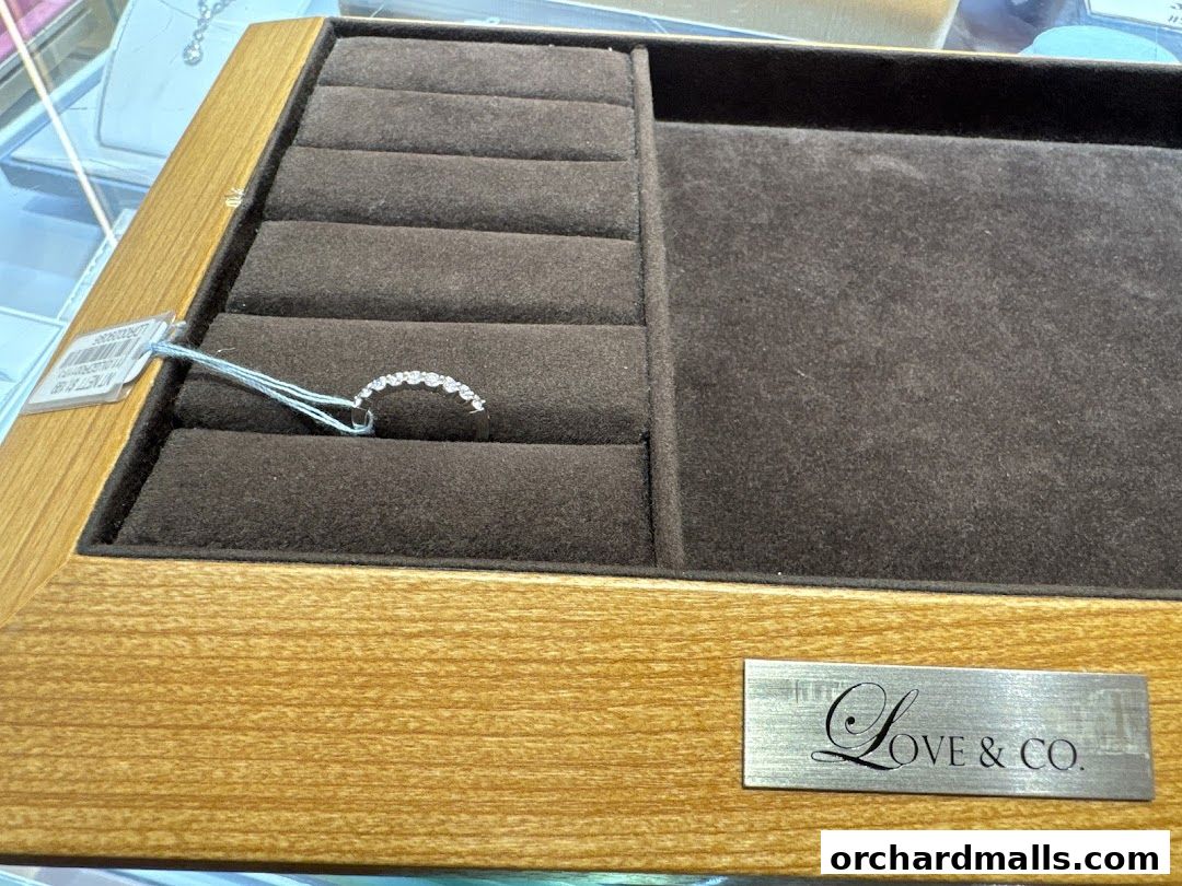 A diamond ring displayed in a velvet-lined jewelry box with the Love & Co. logo.