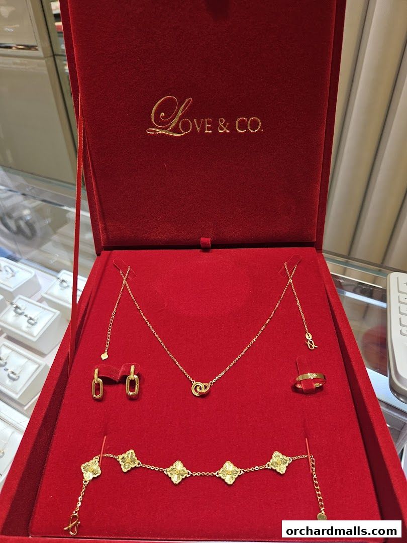 A red velvet box displays exquisite gold jewelry, including a necklace, earrings, bracelet, and rings.