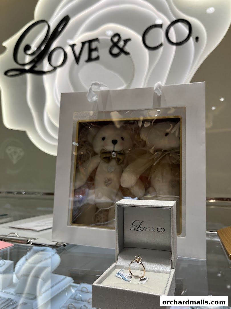 A diamond ring is displayed in a box next to teddy bears in a jewelry store.