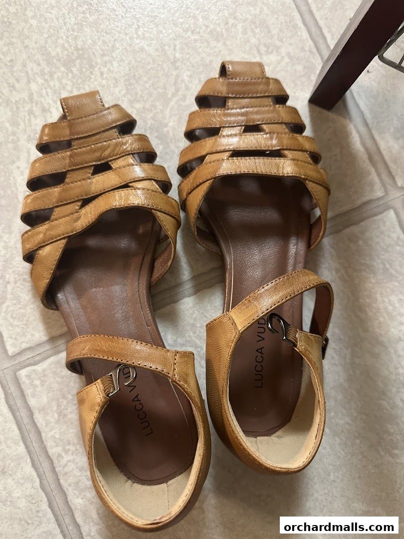 A pair of tan leather gladiator-style sandals with intricate strap detailing.
