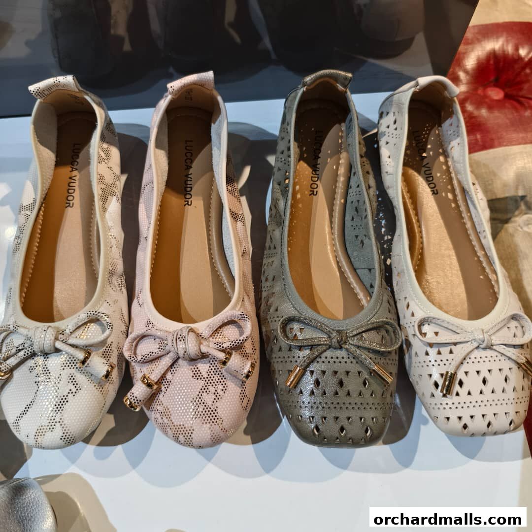 A display of four stylish women's ballet flats in various colors and patterns.