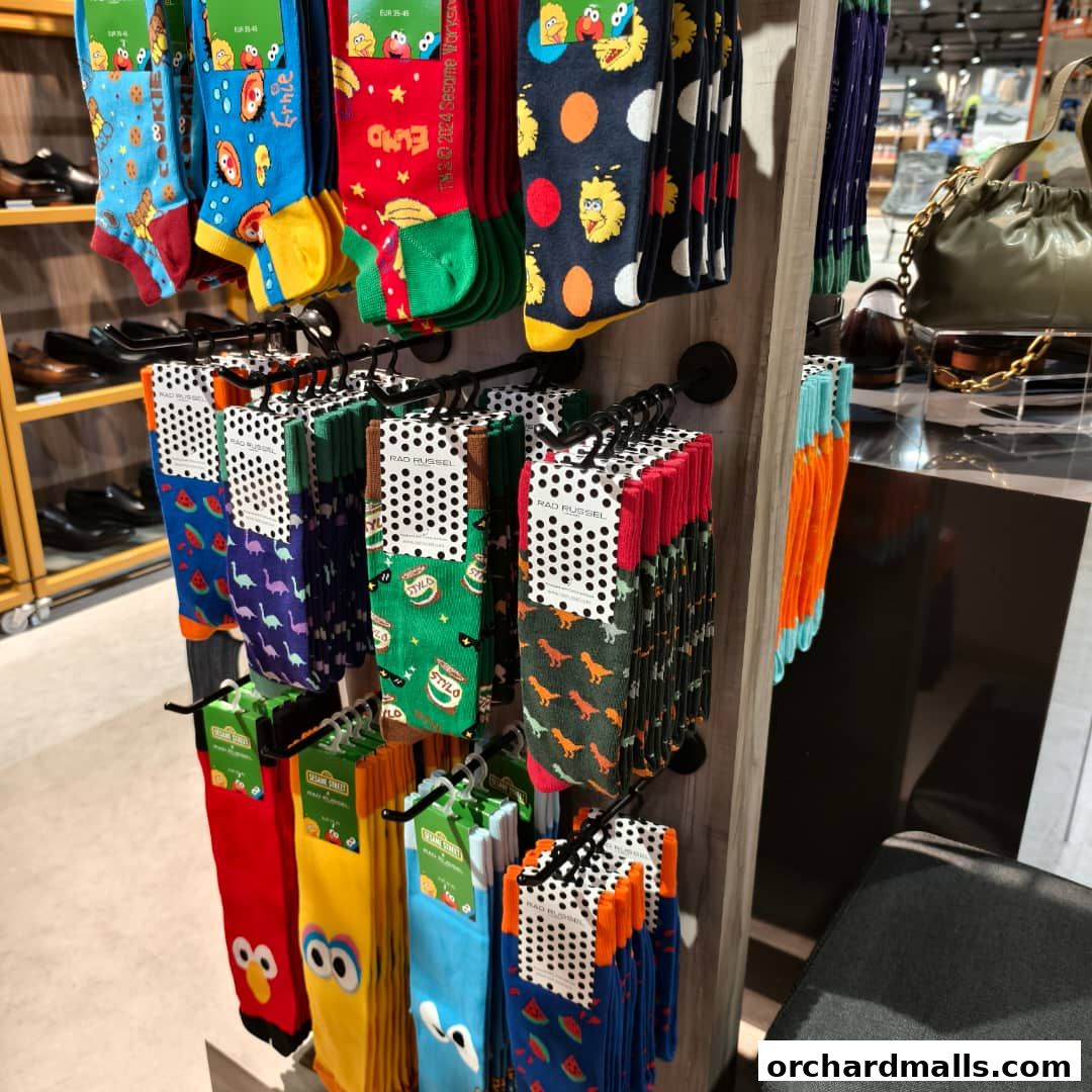 A display of colorful socks with various patterns, including Sesame Street characters and dinosaurs.