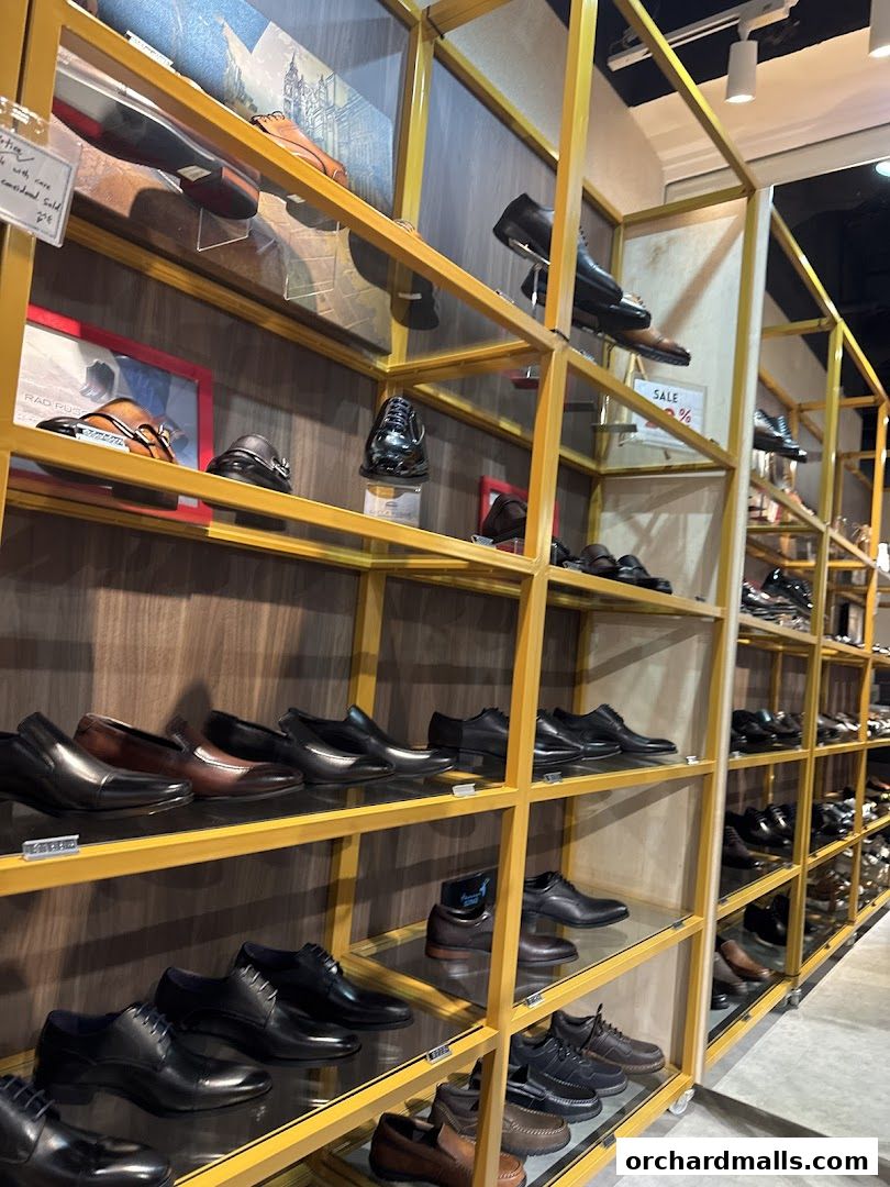 A well-lit shoe store displaying a wide variety of men's dress shoes on yellow shelves.