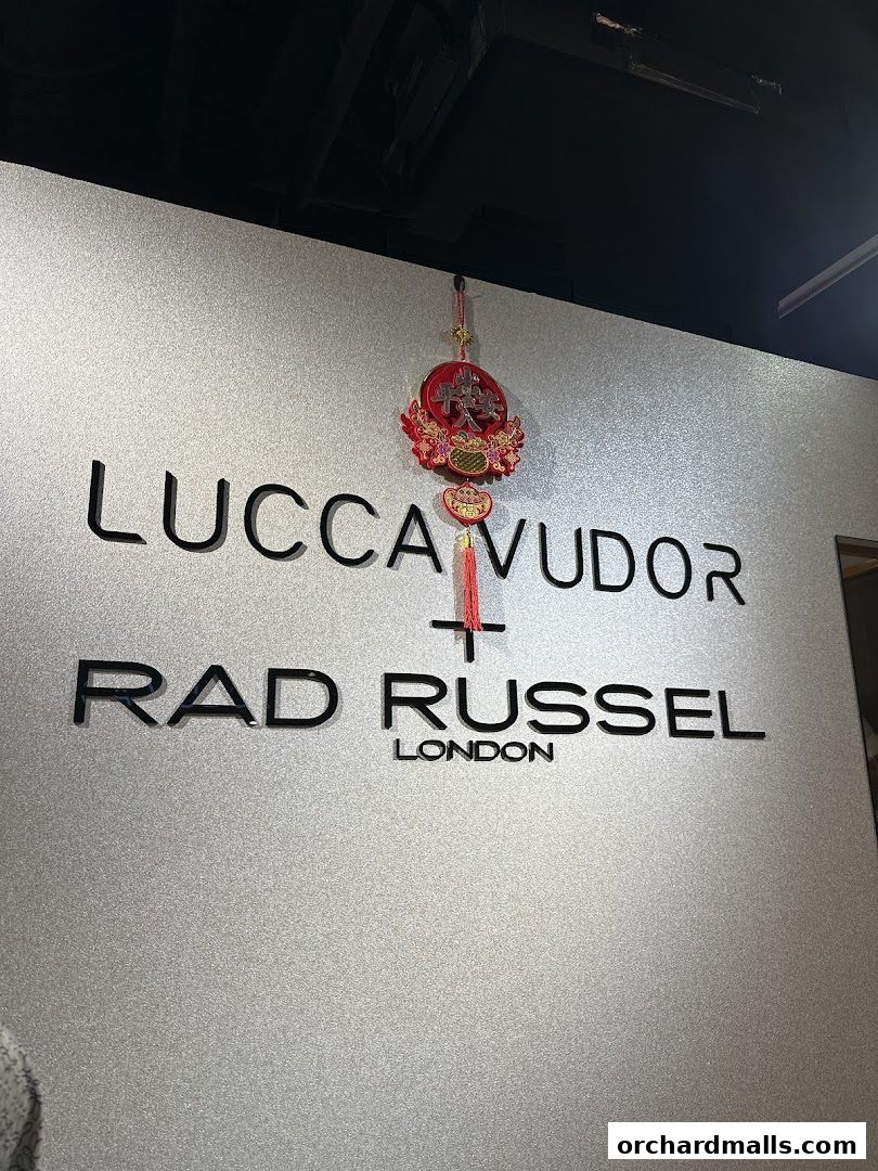 The shop name 'LUCCA VUDOR RAD RUSSEL LONDON' is displayed on a textured wall with a decorative ornament.