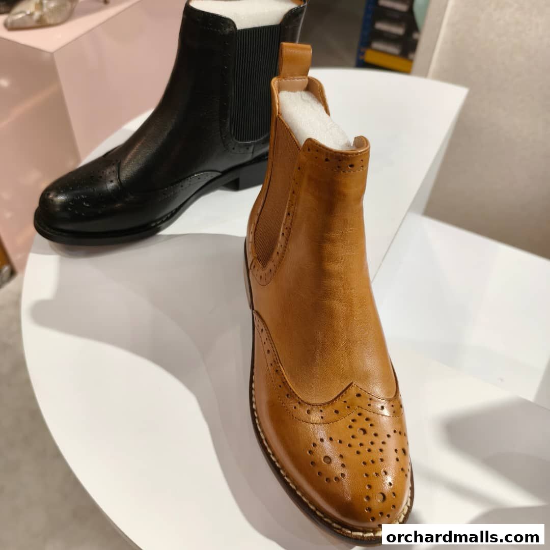 Stylish leather boots, one black and one tan, displayed on a white surface.
