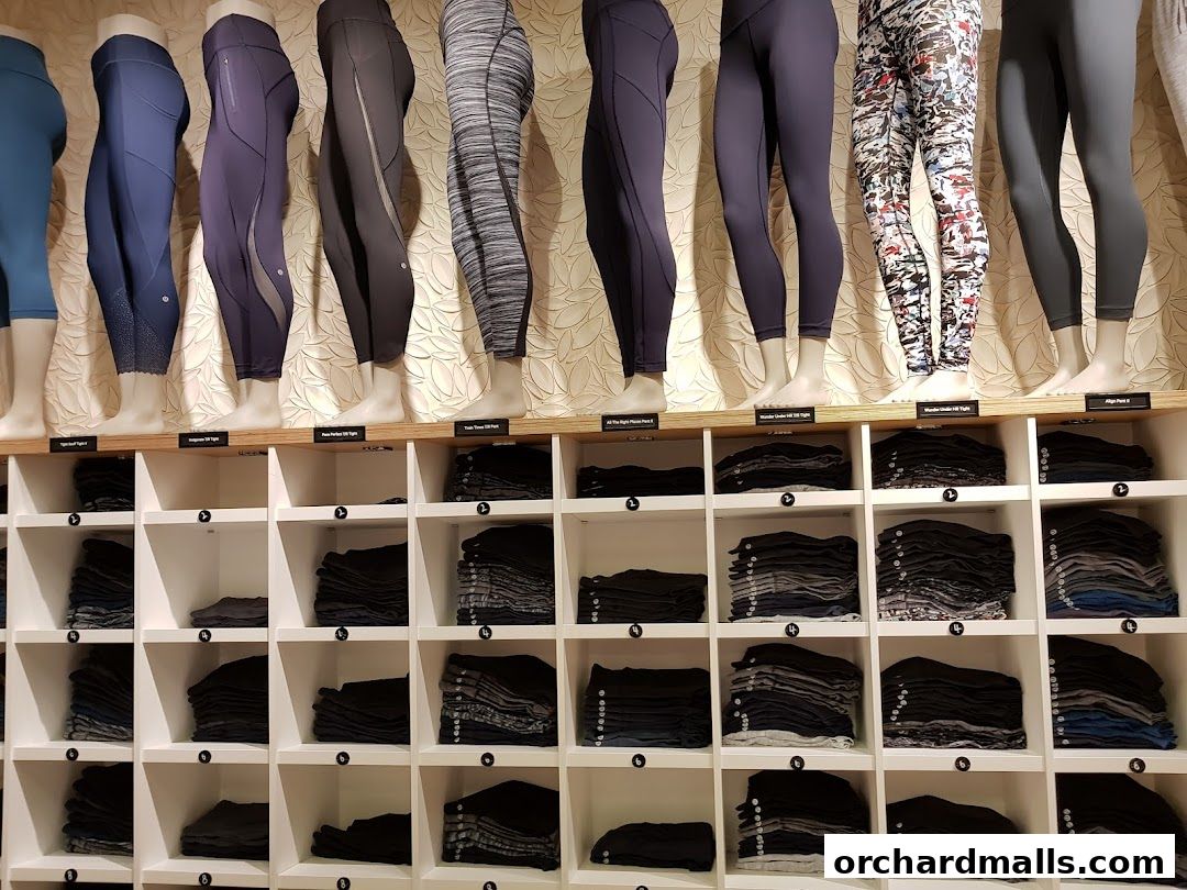 Lululemon store display featuring mannequins wearing leggings and folded leggings on shelves.