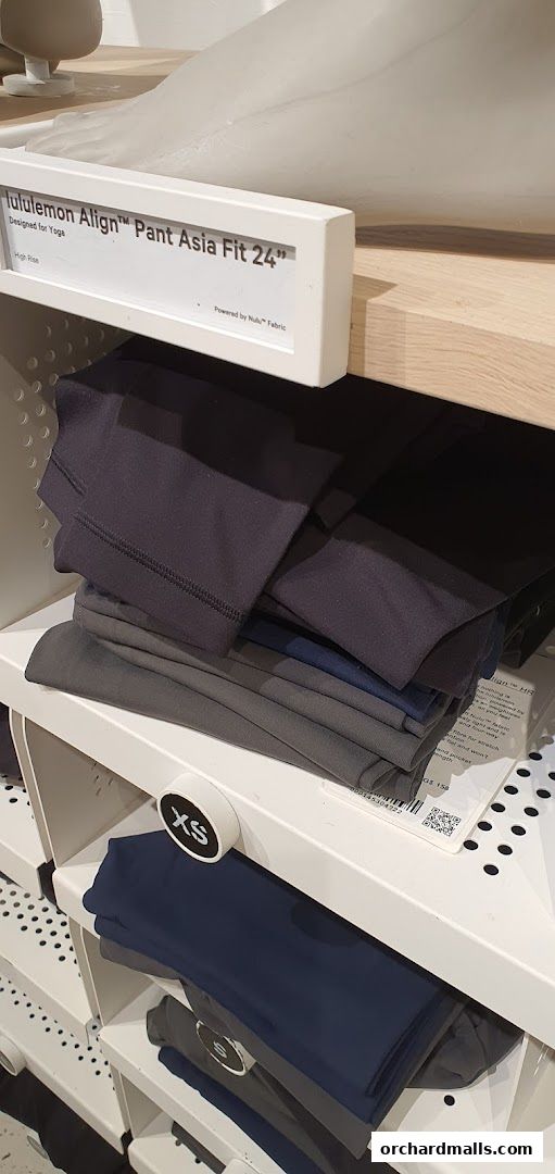 Neatly folded lululemon Align pants in various dark colors displayed on shelves.